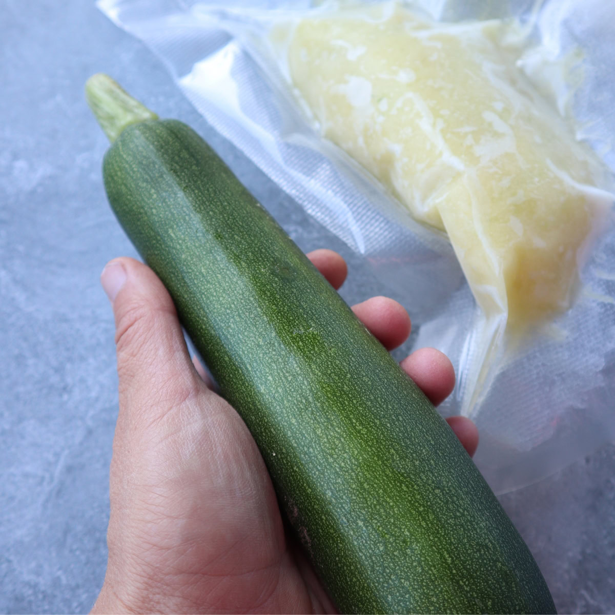 hand holding zucchini