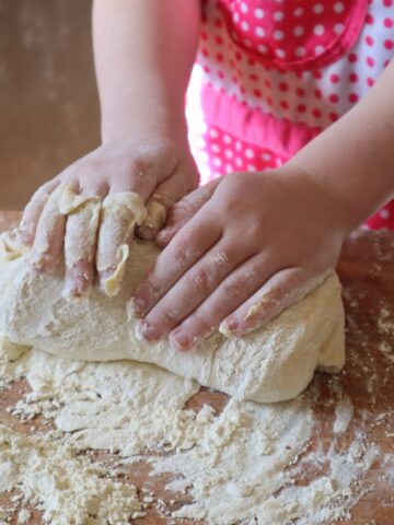 child's hands kneading bread dough