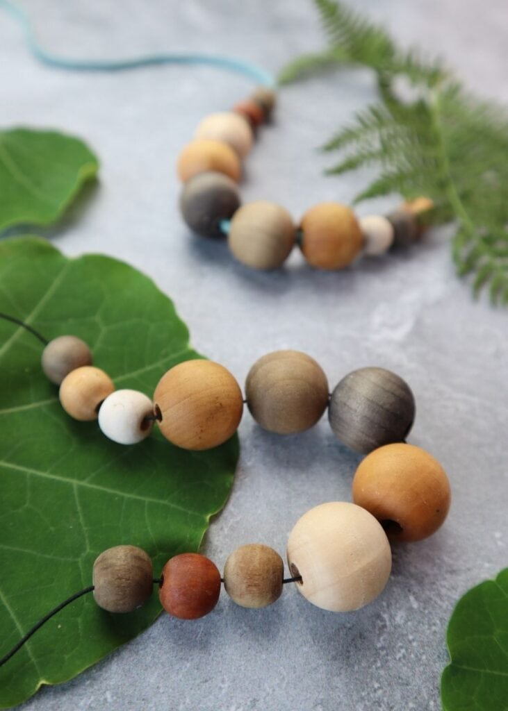 Close-up of wooden bead necklaces for sale and displayed at an outdoor  market Stock Photo - Alamy