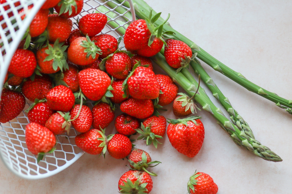 white basket full of strawberries and asparagus