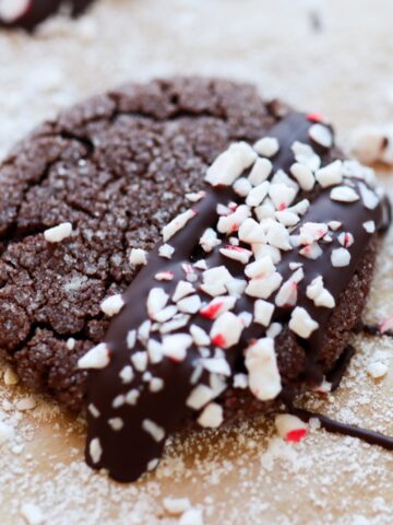 dark chocolate crinkle cookie drizzled with chocolate and sprinkled with crushed candy cane