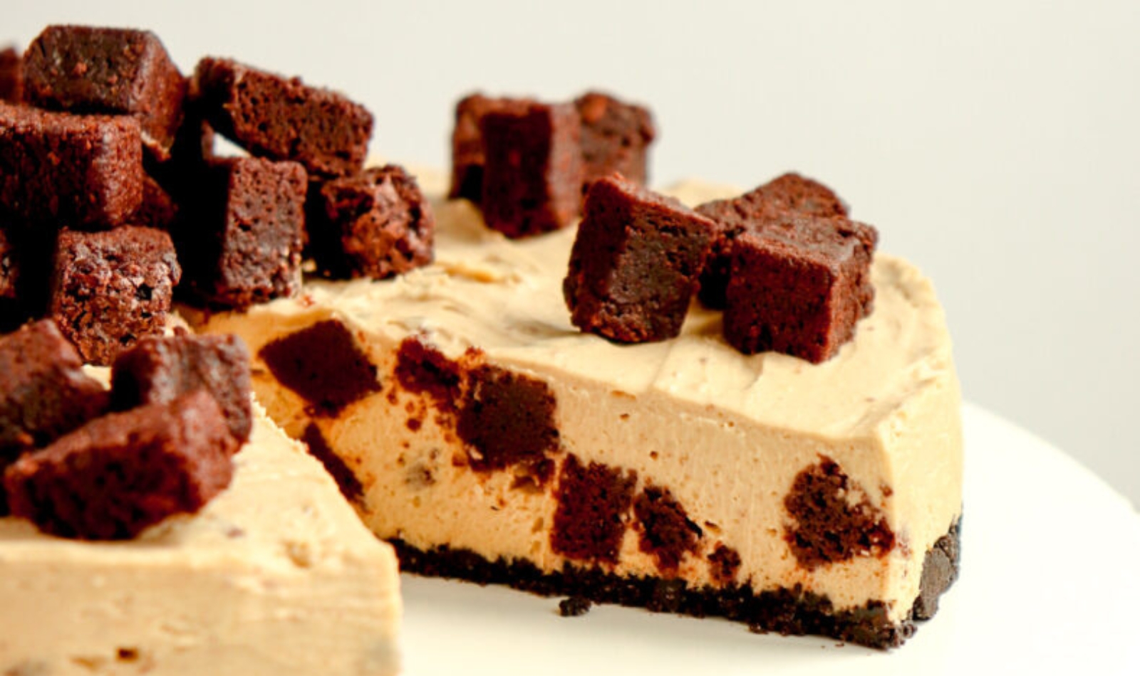 a coffee brownie cheesecake with a slice taken out of it