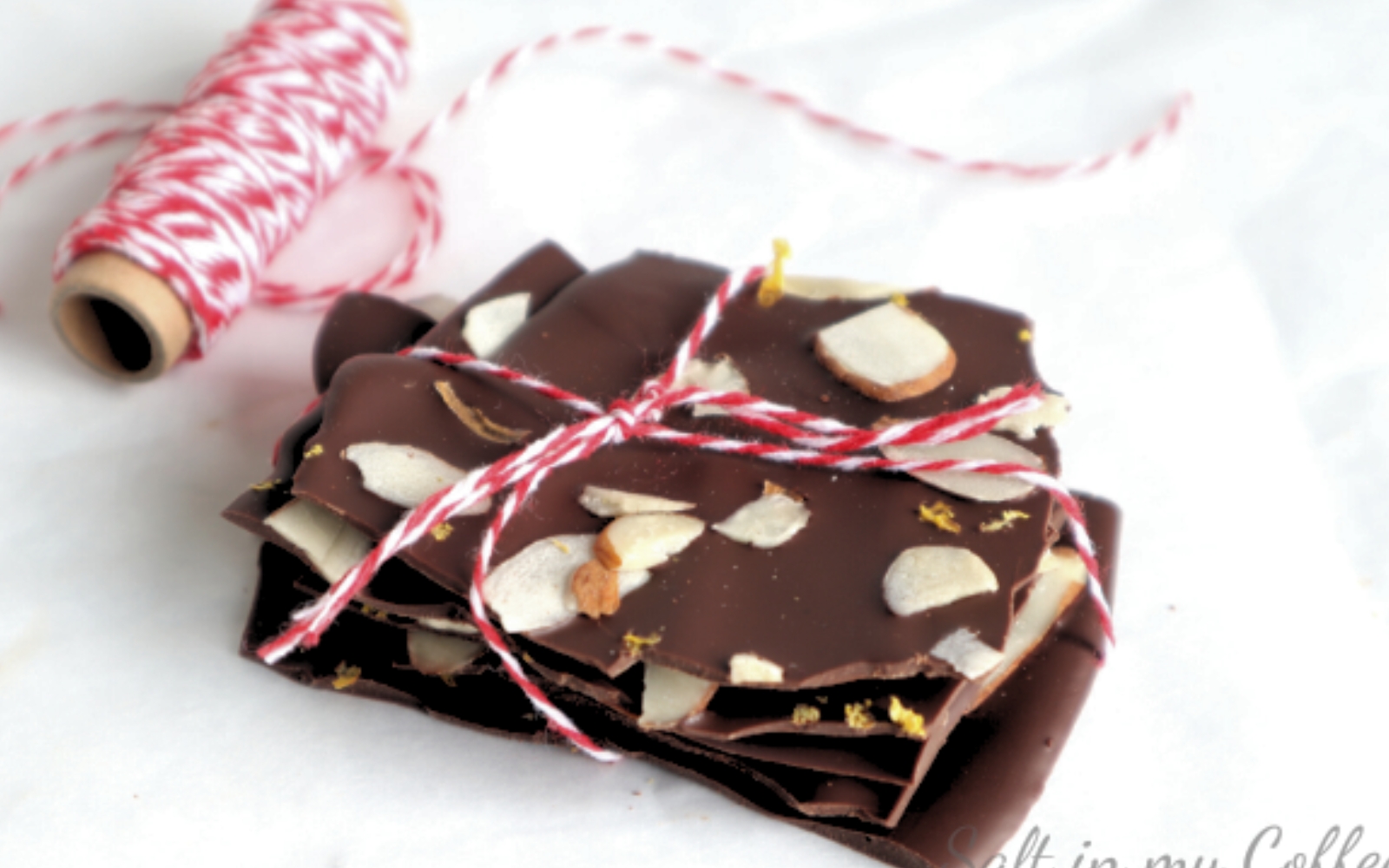 pieces of dark chocolate orange and almond bark tied with baker's twine