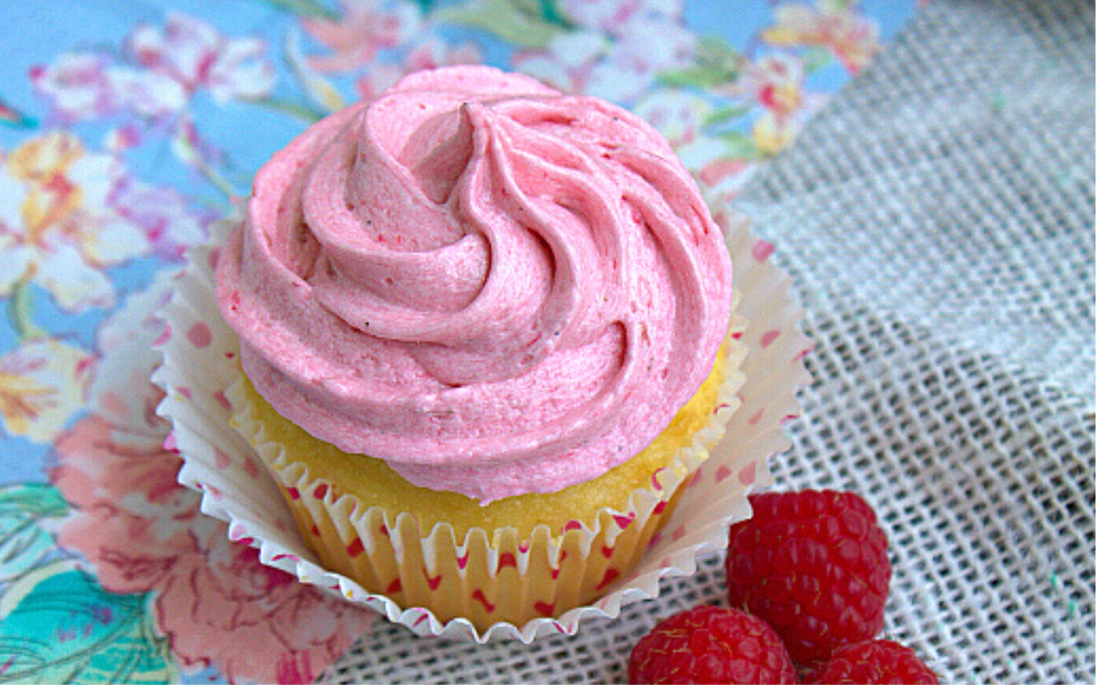 a raspberry cupcake with pink frosting