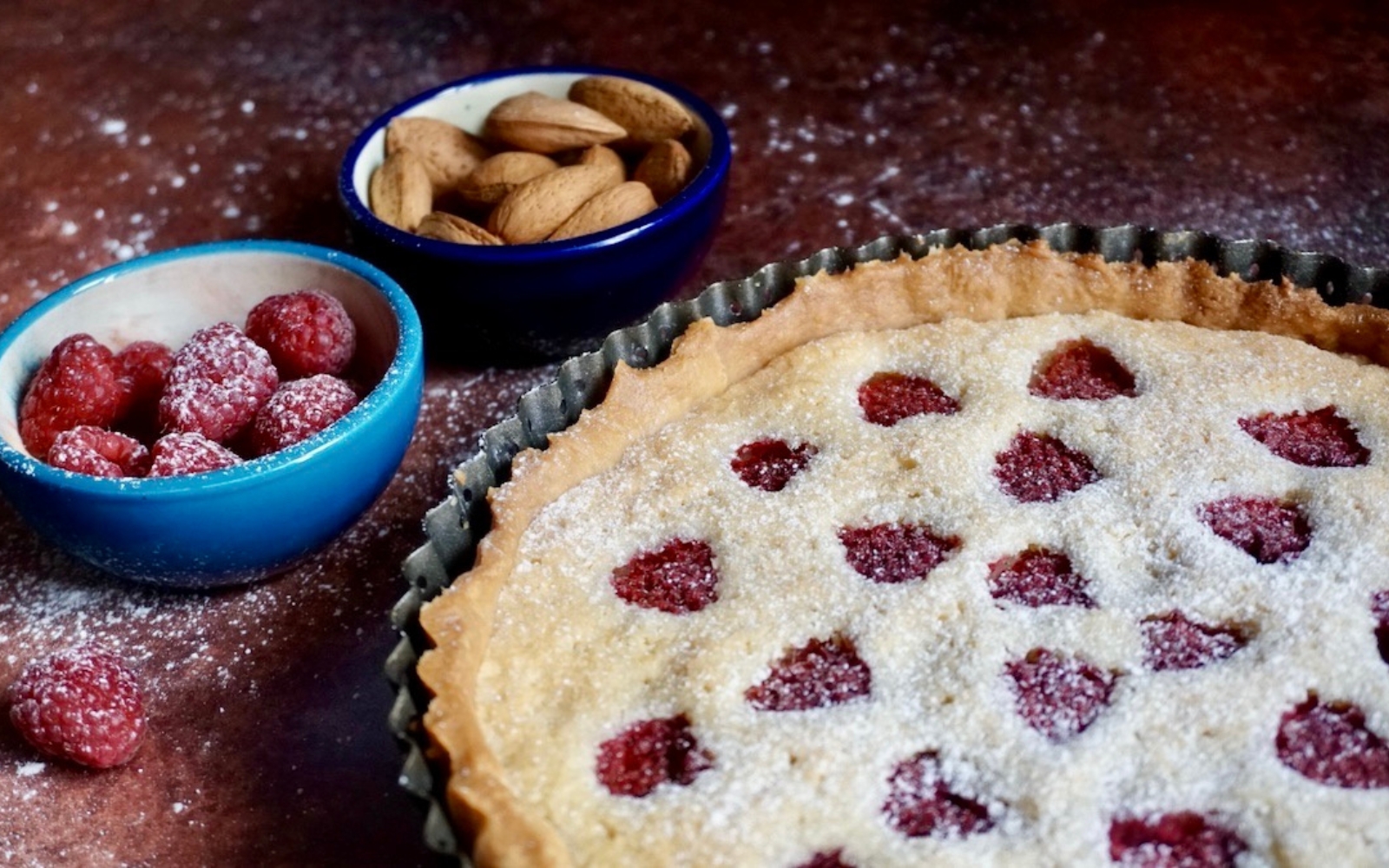 a raspberry frangipane tart in a tart pan