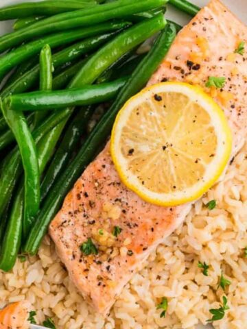 baked salmon on a plate with green beans and rice