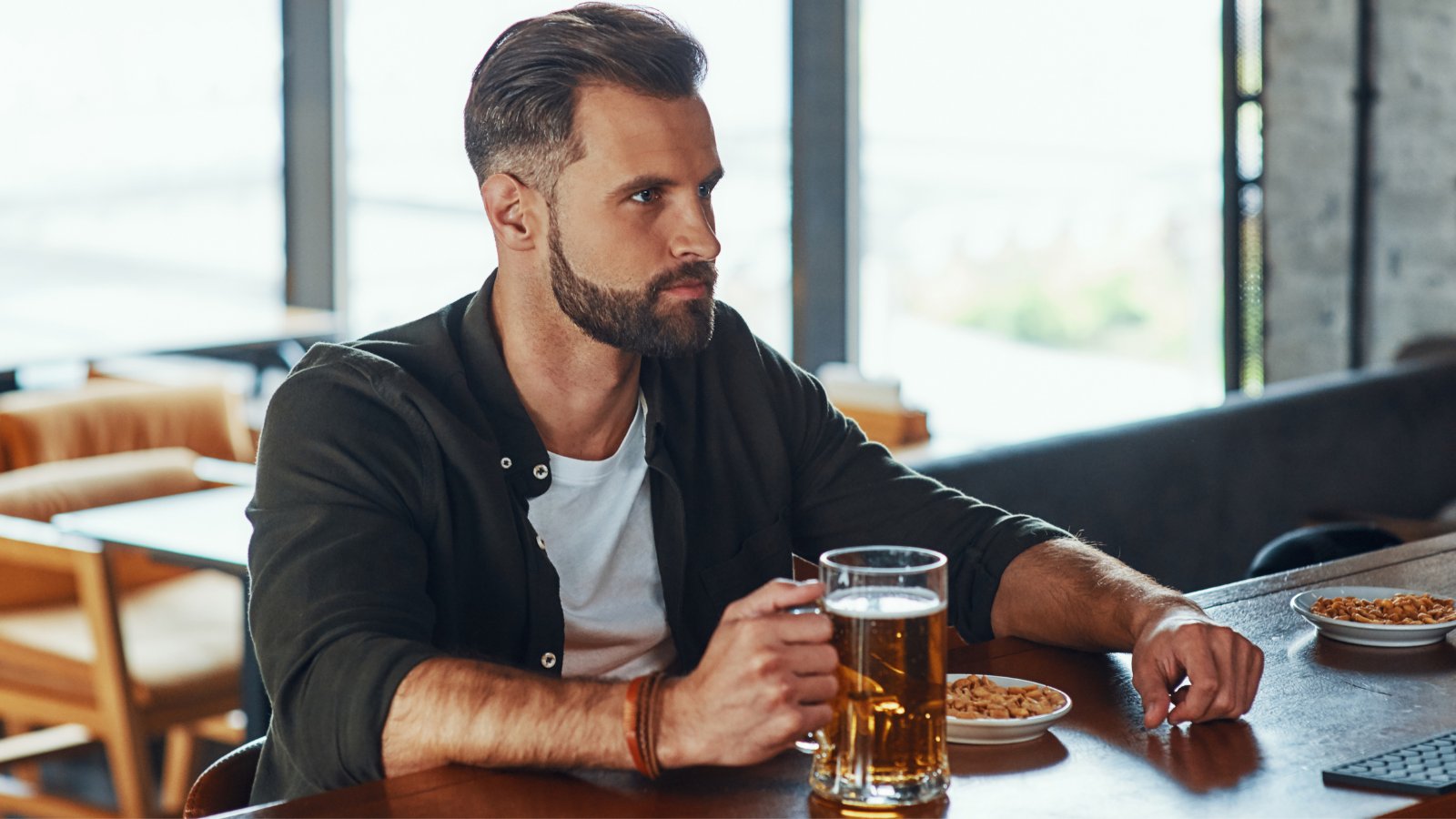 Man drinking beer alone at pub.