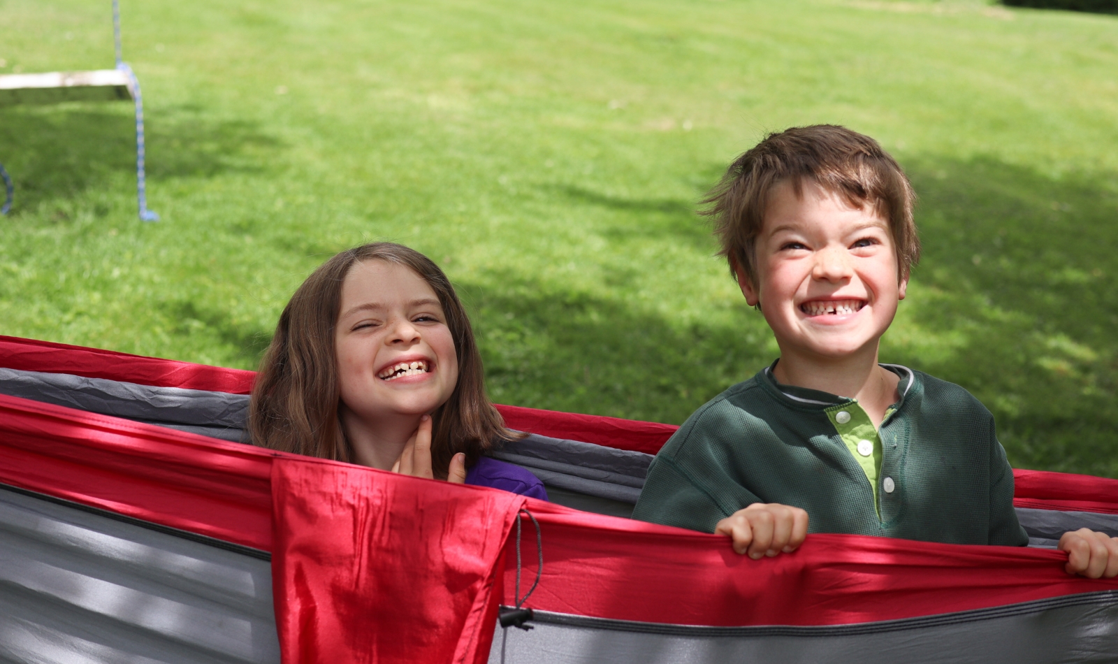 two happy kids in a red hammock