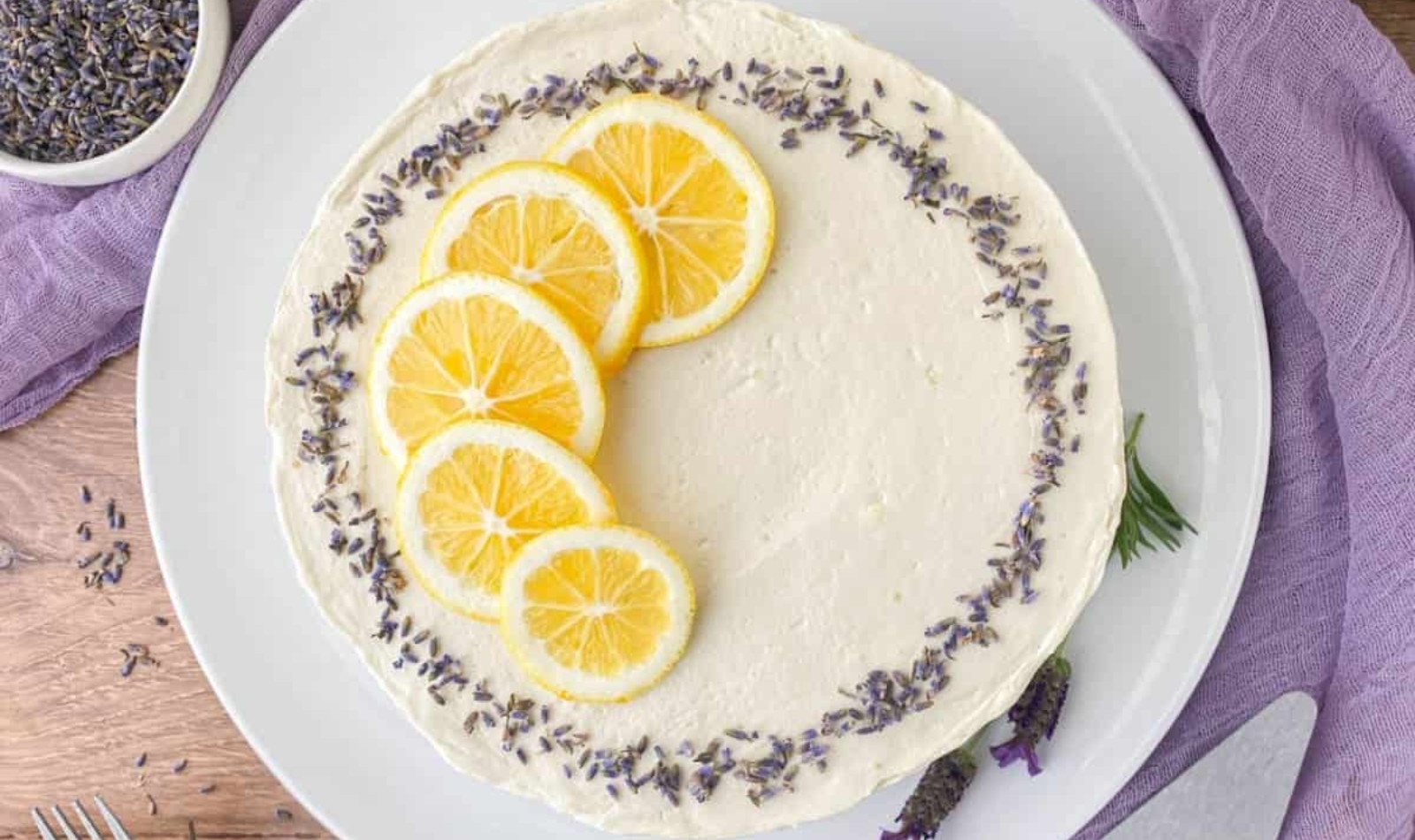  a lavender lemon cake garnished with bright yellow lemon slices and lavender flowers