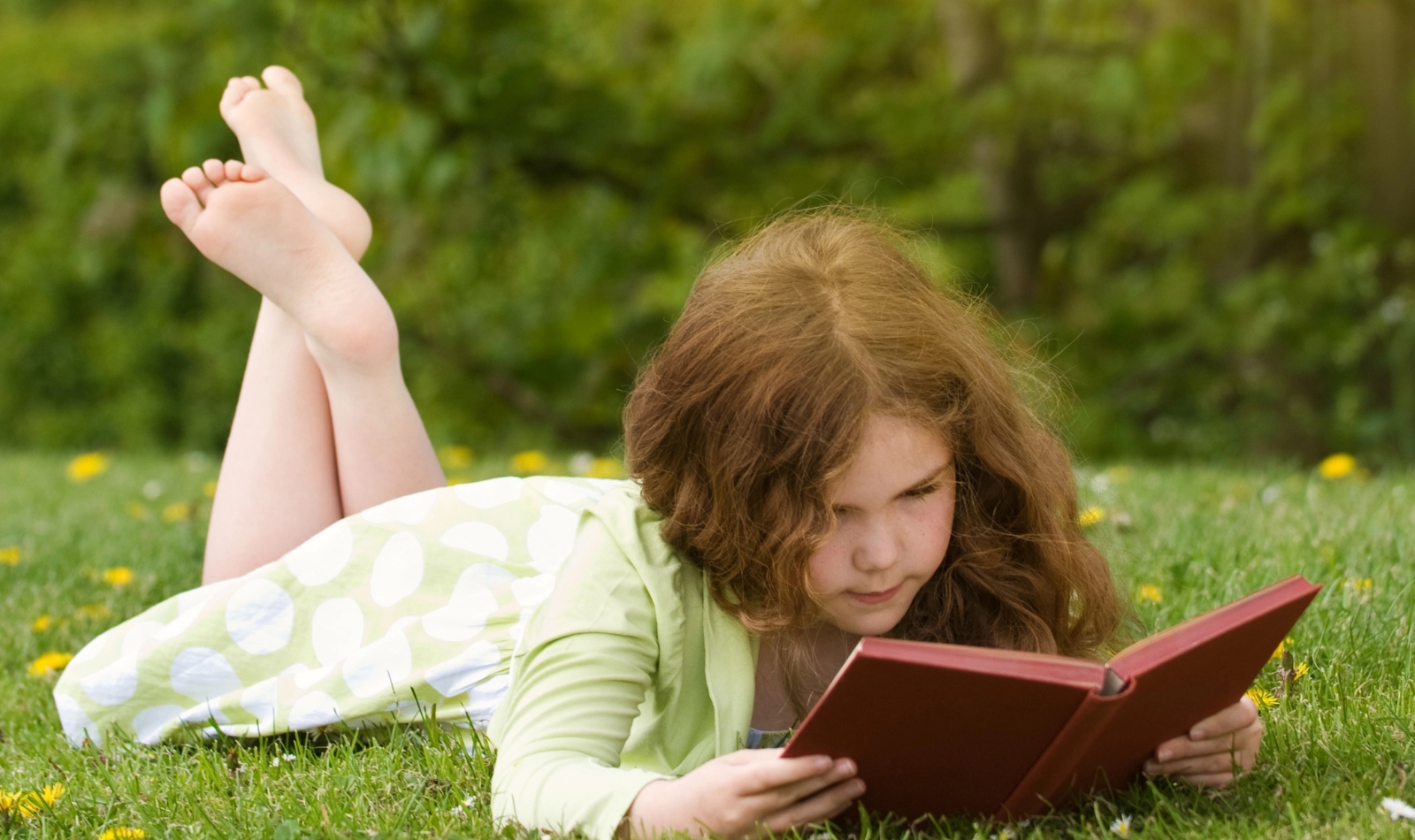 little girl reading outside