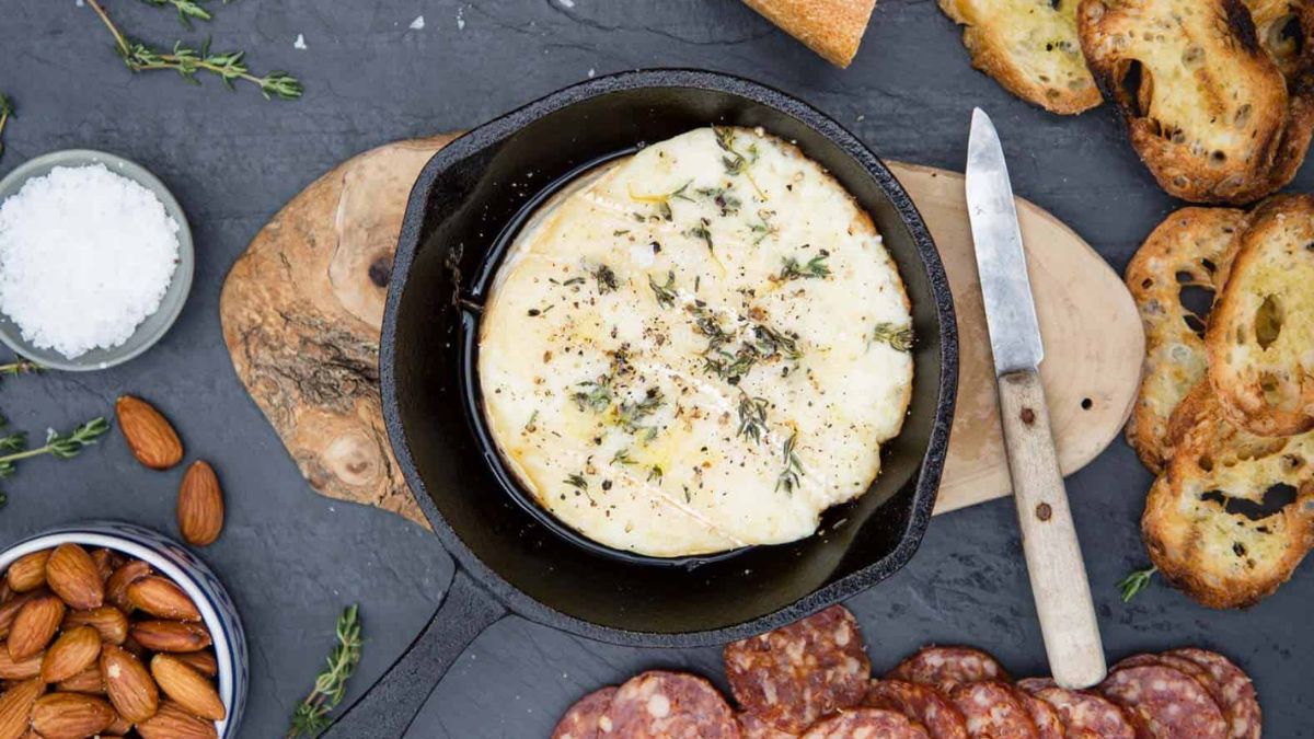Baked Brie served with herbs and crusty bread