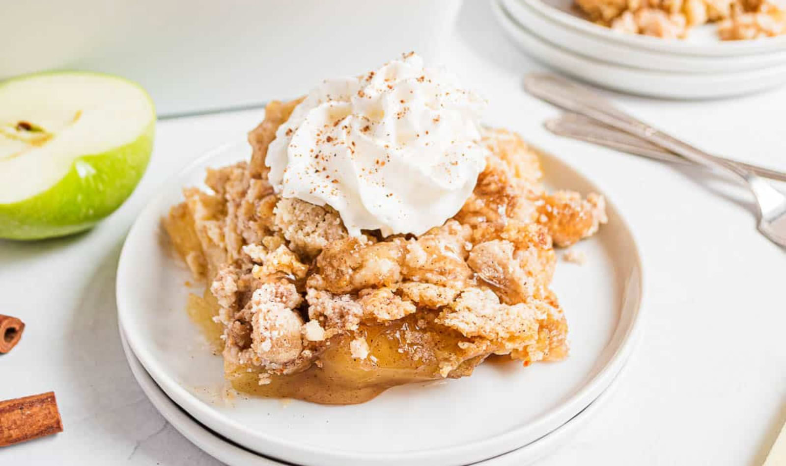 a piece of apple dump cake with whipped cream
