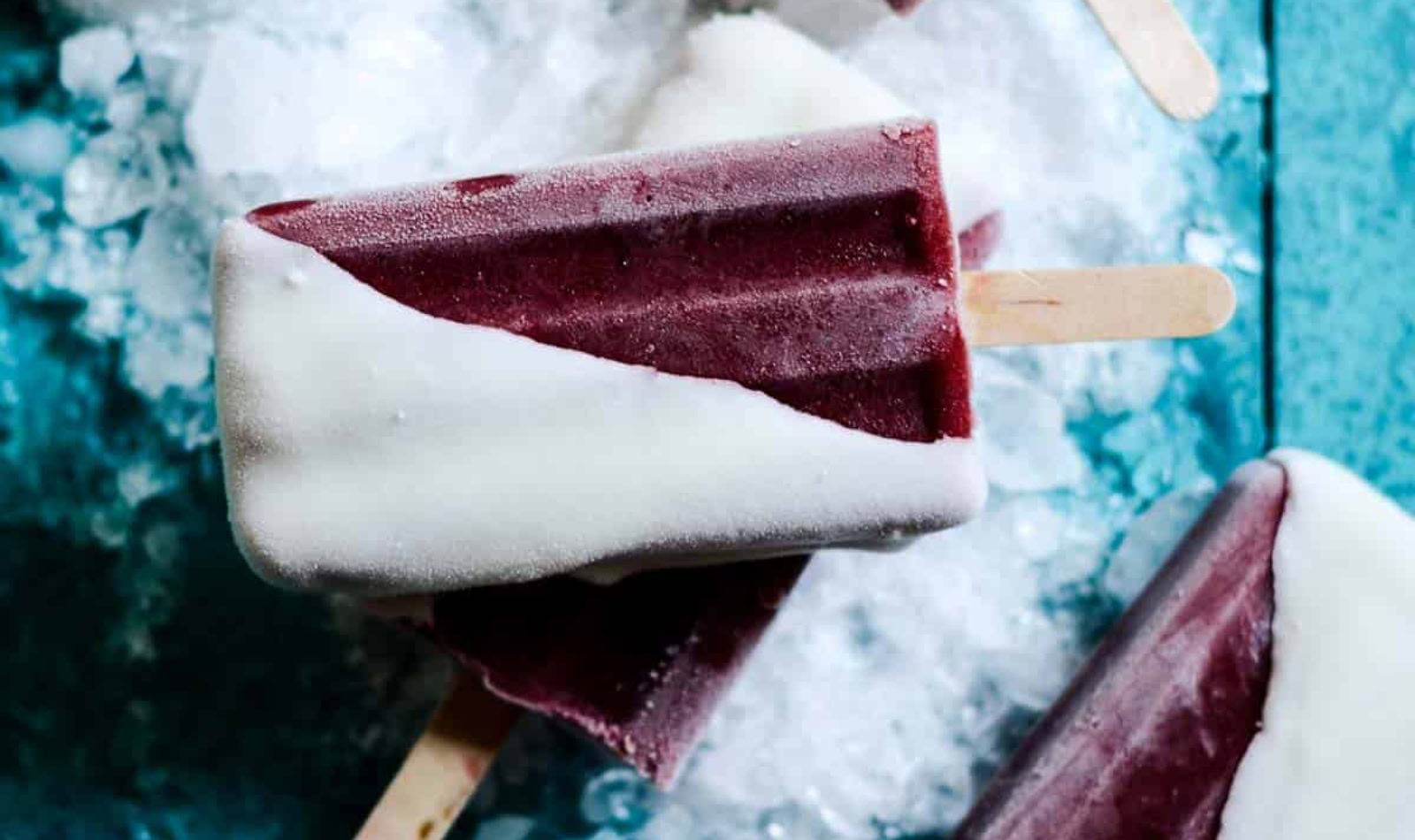 Cherry popsicles on a blue table