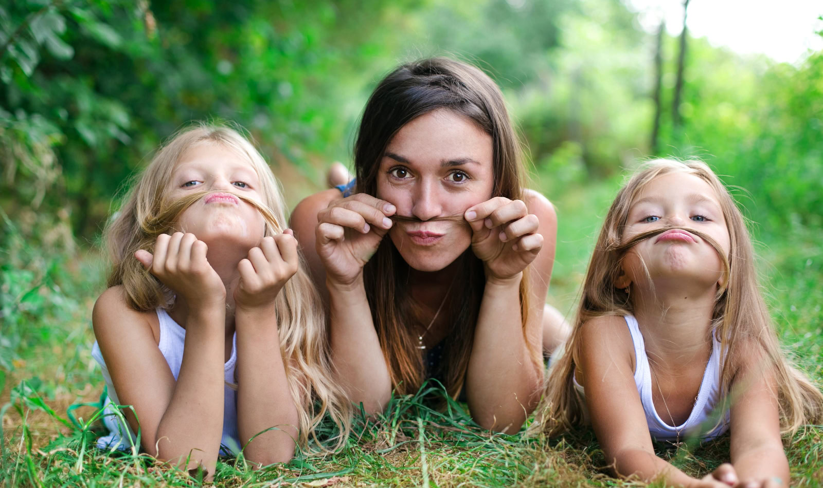 young woman and two girls acting goofy with their hair