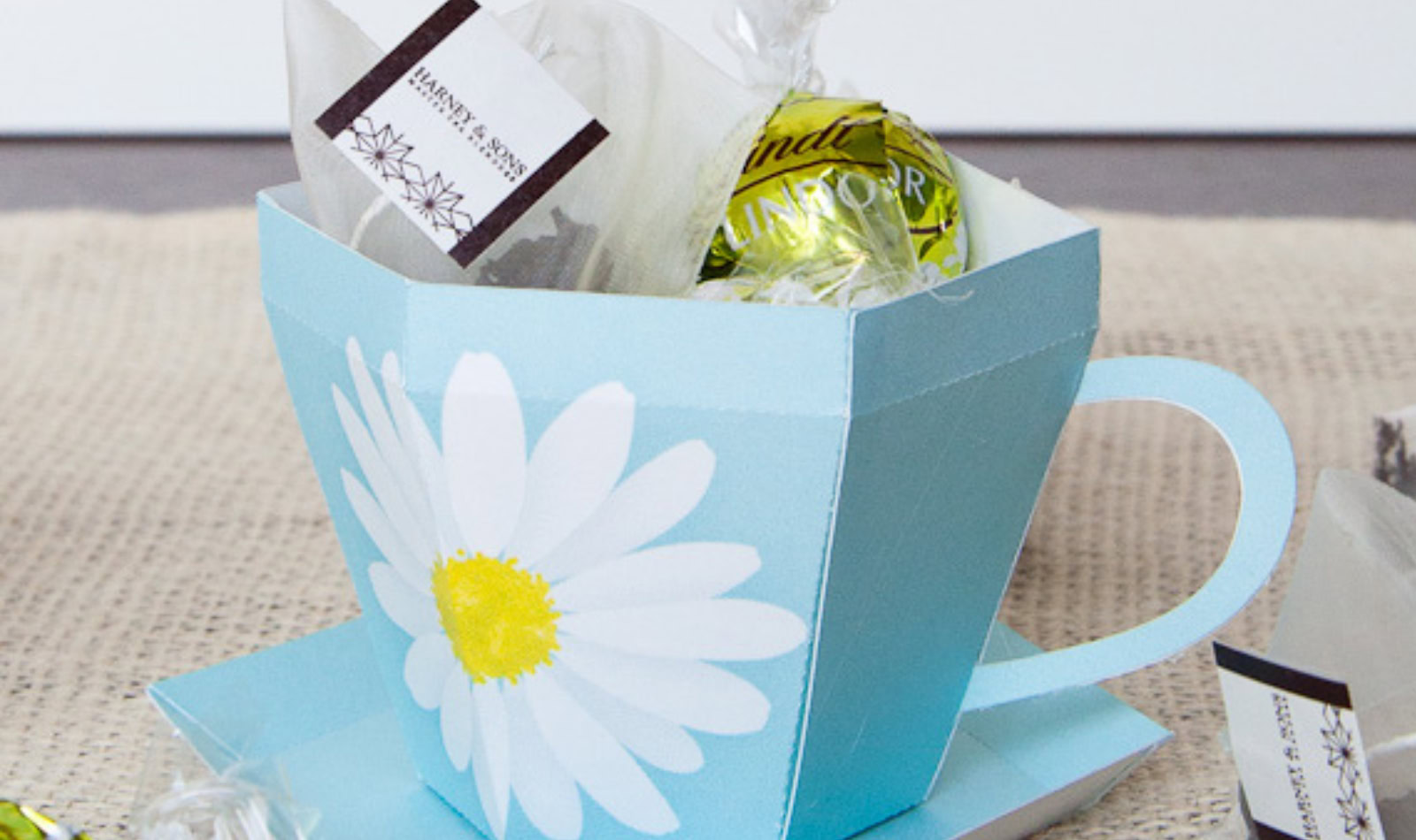 Image of paper tea cup holding tea bags and chocolate balls.