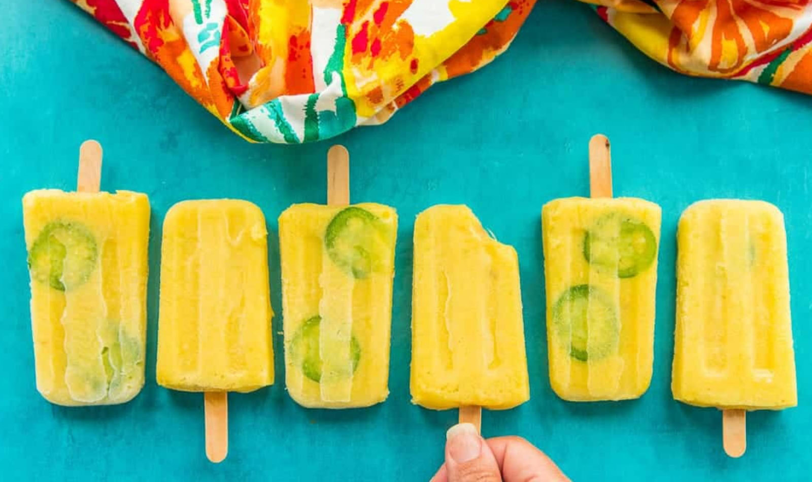 bright pineapple and jalapeño popsicles in a row