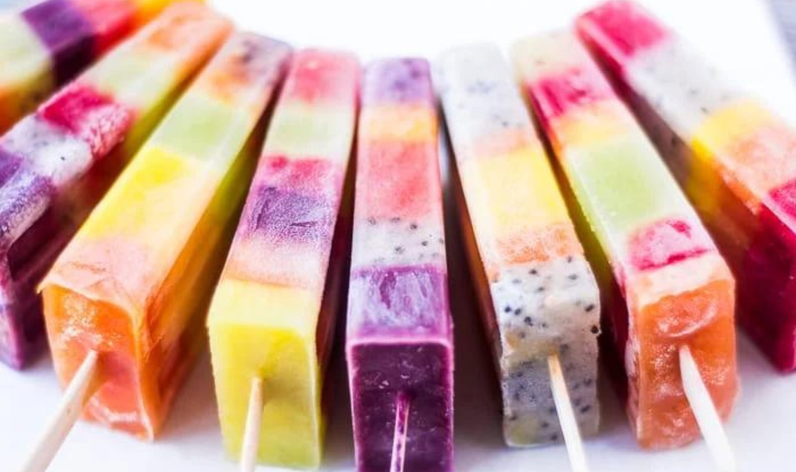 A display of rainbow fruit popsicles
