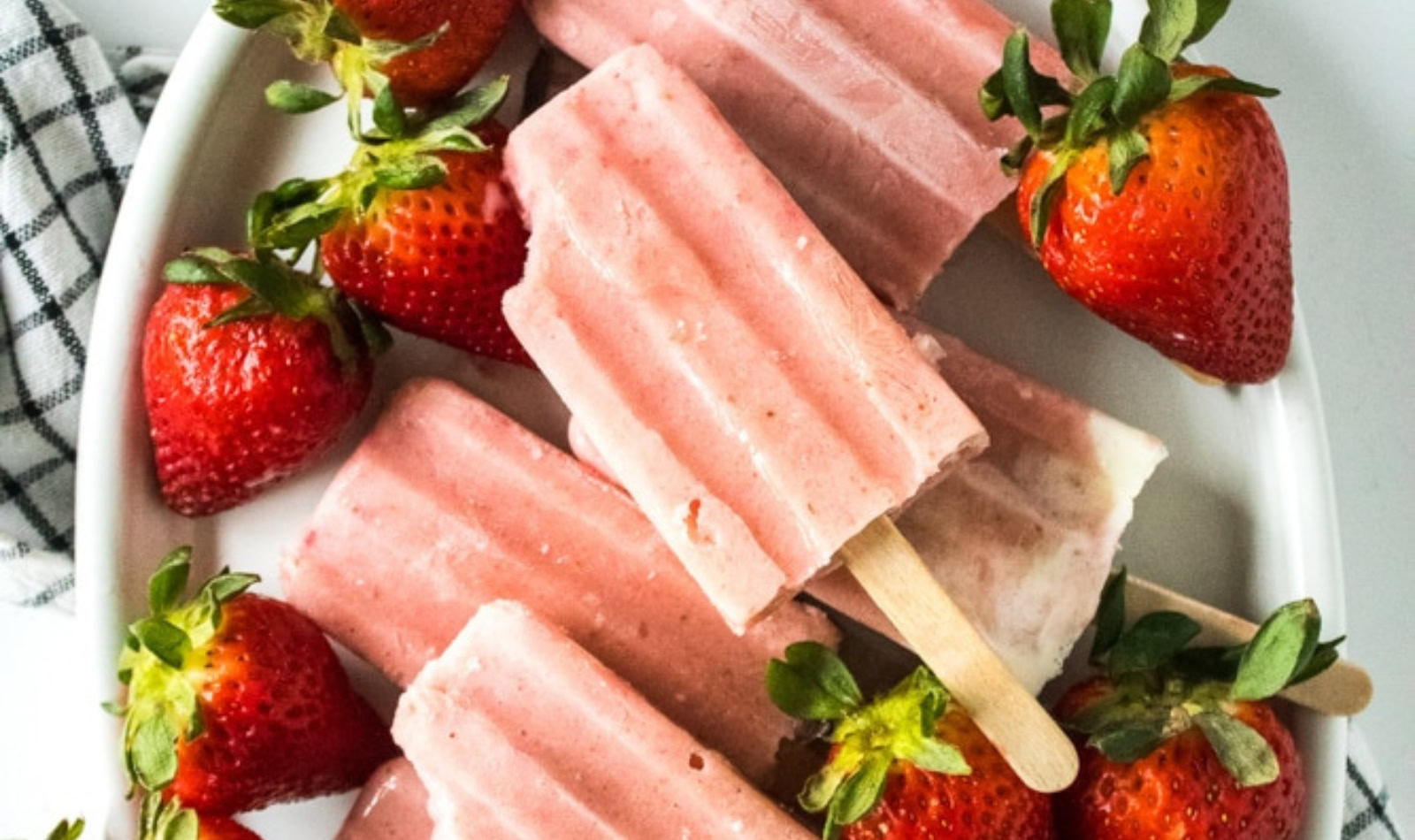 a tray of strawberry banana popsicles