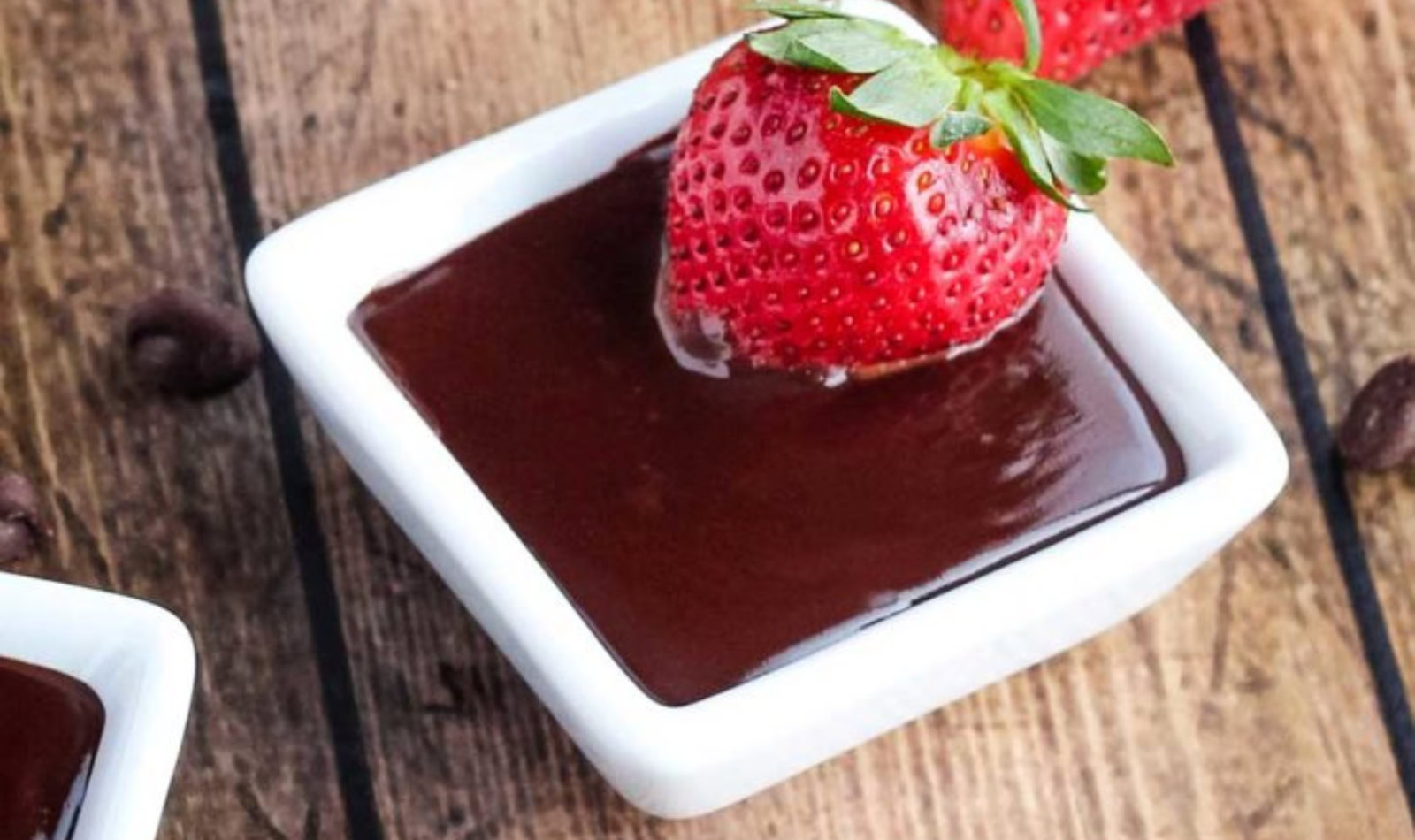 Image of chocolate dip in a white square bowl with strawberries