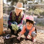 woman and little girl planting a garden