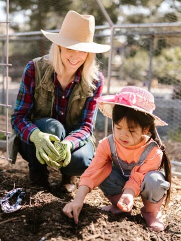 woman and little girl planting a garden