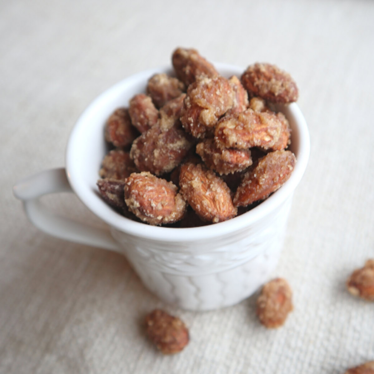 A teacup filled to overflowing with holiday brown sugar candied almonds