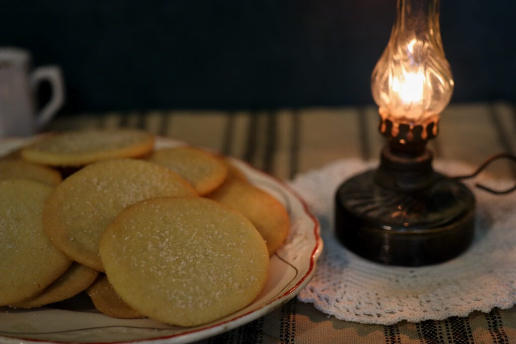 a plate of old fashioned lemon snaps cookies by an antique table lamp