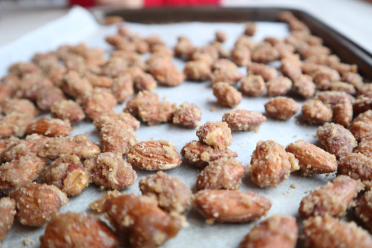 a baking sheet covered with a batch of brown sugar candied almonds