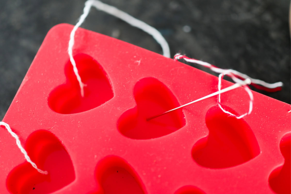 using a needle to thread string through a silicone mold
