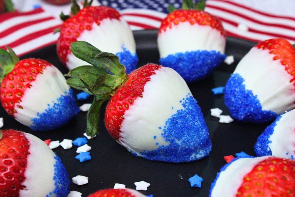 a plate of red white and blue dipped strawberries