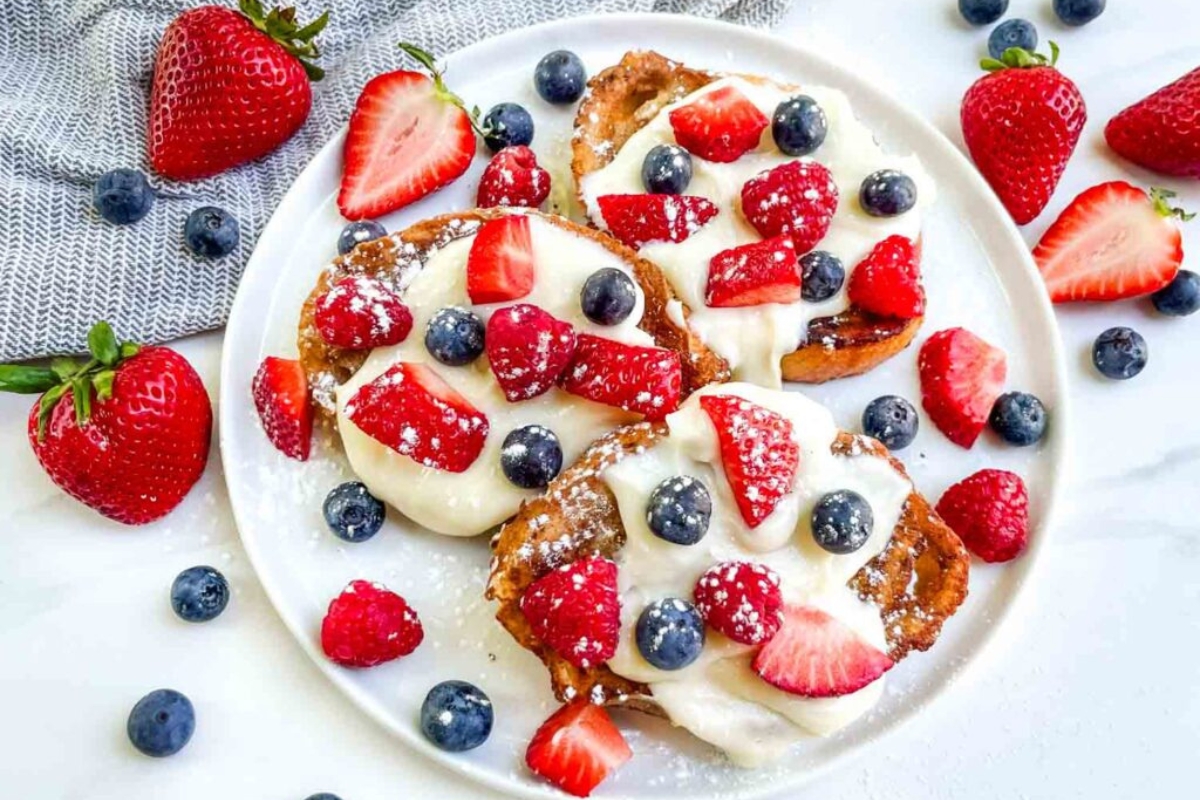 beautiful plate of French toast with mixed red and blue berries
